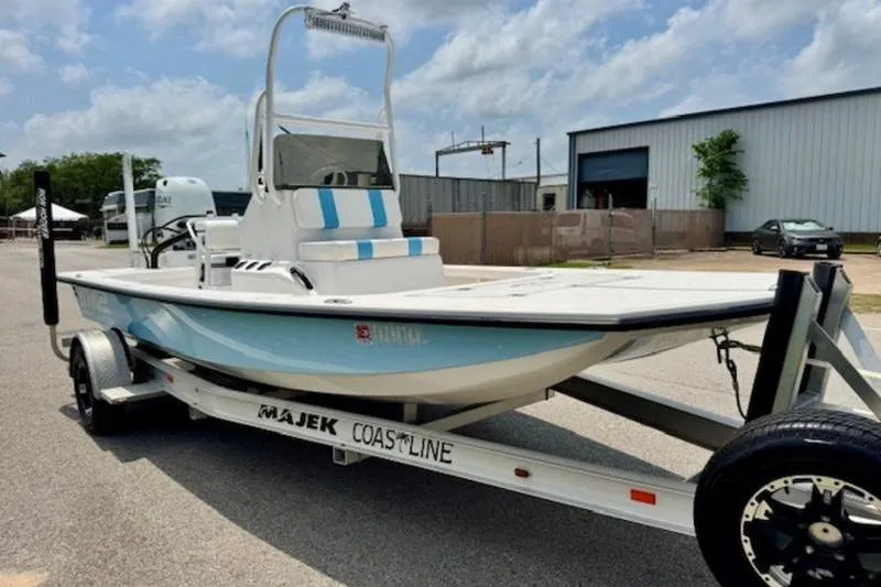 Slide: The Image of 2024 Majek 18 M2 boat on trailer, parked outdoors under cloudy sky. - 4
