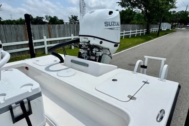 Slide: The Image of 2024 Majek 18 M2 boat with Suzuki outboard motor, parked on a street. - 6