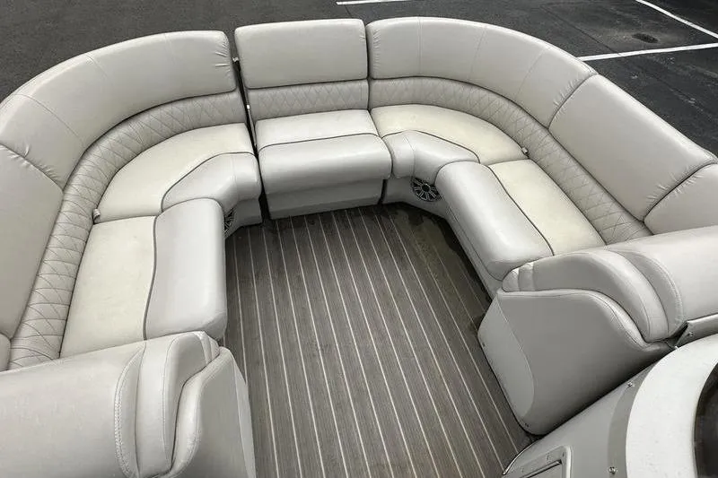 Slide: The Image of 2026 Bennington 2250 GSR boat interior with luxurious beige seating and wood-style flooring. - 19