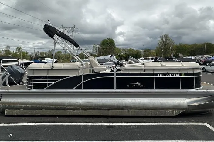 Slide: The Image of 2026 Bennington 2250 GSR pontoon boat parked outdoors under cloudy skies. - 8