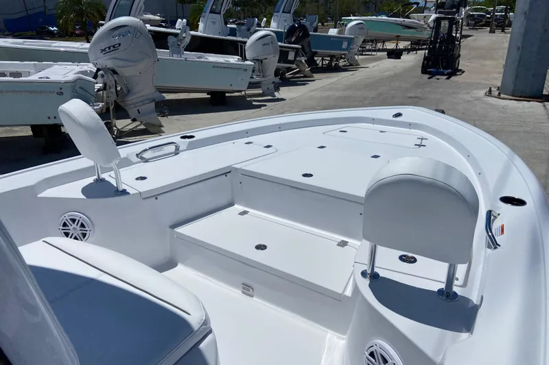 Slide: The Image of 2026 Sportsman Masters 247 Bay Boat interior with seating and storage, docked outdoors. - 13