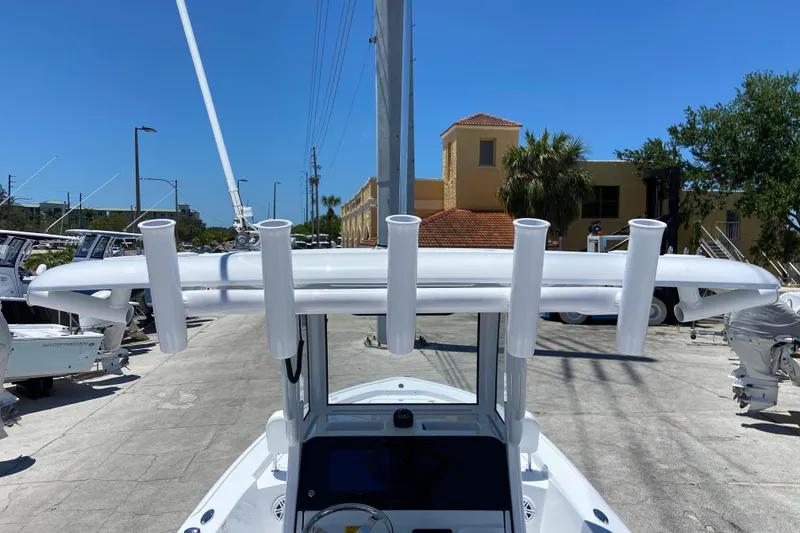 Slide: The Image of 2026 Sportsman Masters 247 Bay Boat with rod holders, docked under clear blue sky. - 24