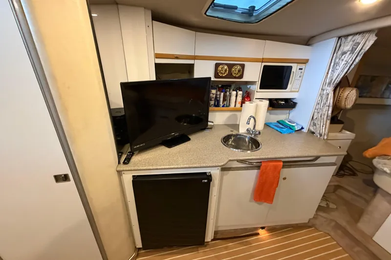 Slide: The Image of 1998 Formula 34 Performance Cruiser interior with kitchenette, TV, and sink. - 23