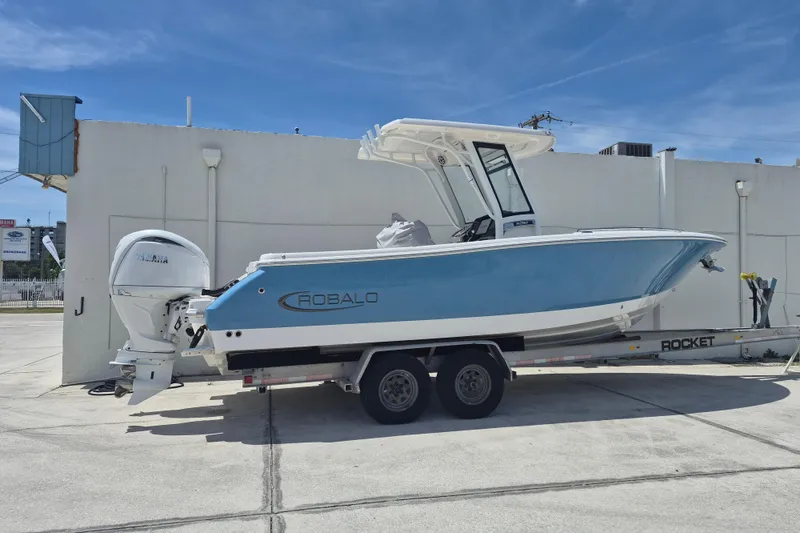 The Image of 2026 Robalo R250 Center Console boat on trailer, parked outdoors. - 1