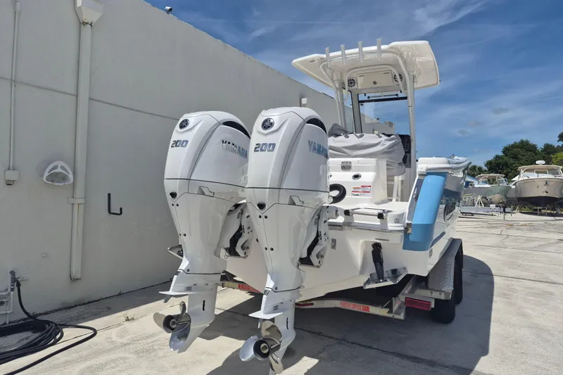 Slide: The Image of 2026 Robalo R250 Center Console boat with dual Yamaha 200 engines, parked outdoors. - 20