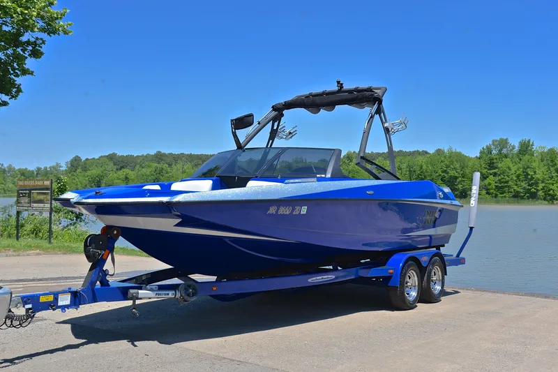Slide: The Image of 2014 Axis A22 boat on trailer by a lake, under clear blue sky. - 10