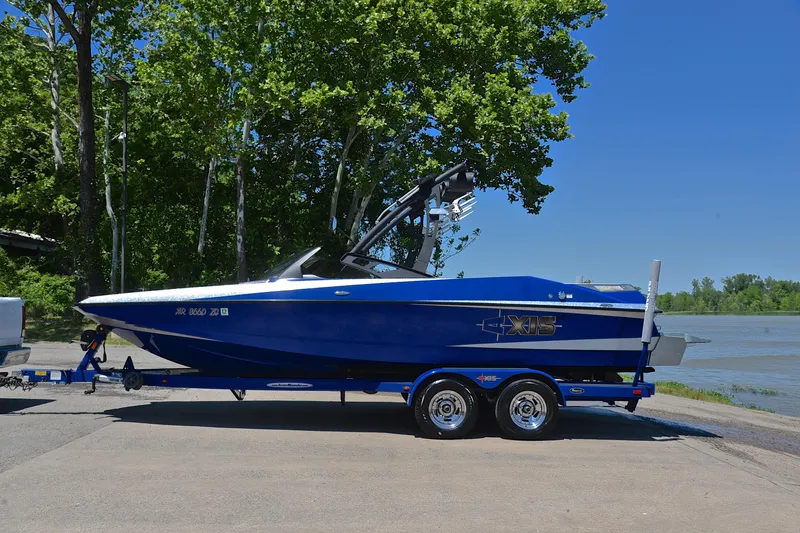 Slide: The Image of 2014 Axis A22 boat on trailer by a lake, surrounded by trees. - 11