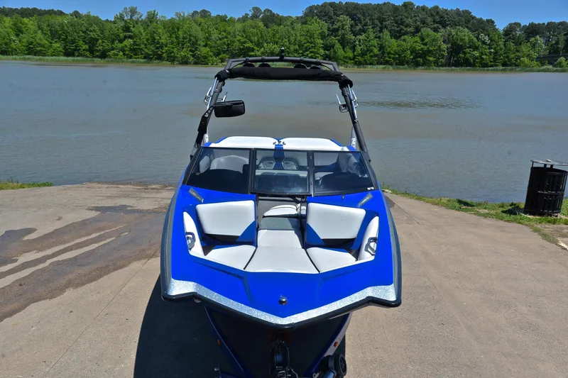 Slide: The Image of 2014 Axis A22 boat in blue, parked by a serene lake with lush greenery. - 17