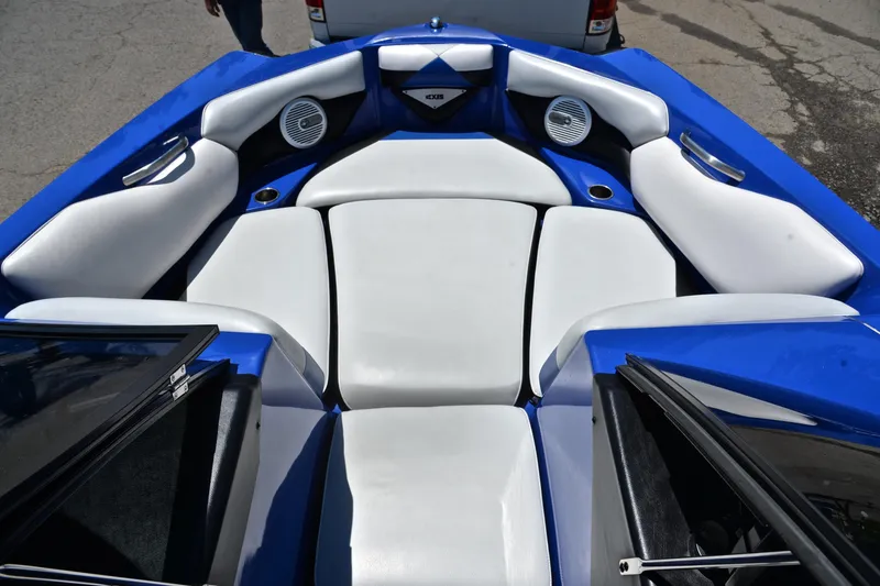 Slide: The Image of 2014 Axis A22 boat interior with blue and white seating, featuring speakers and cup holders. - 21