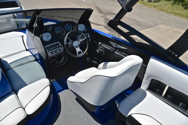 Slide: The Image of Interior of a 2014 Axis A22 boat featuring a sleek dashboard and comfortable seating. - 24