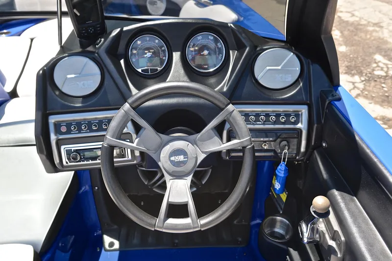 Slide: The Image of 2014 Axis A22 boat dashboard with steering wheel and control panel. - 25