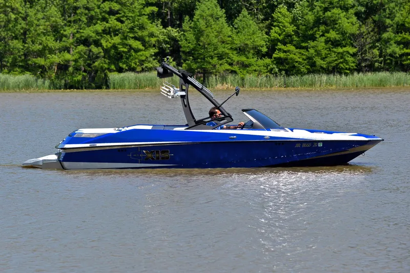 Slide: The Image of 2014 Axis A22 boat in blue on a calm lake with green trees in background. - 7