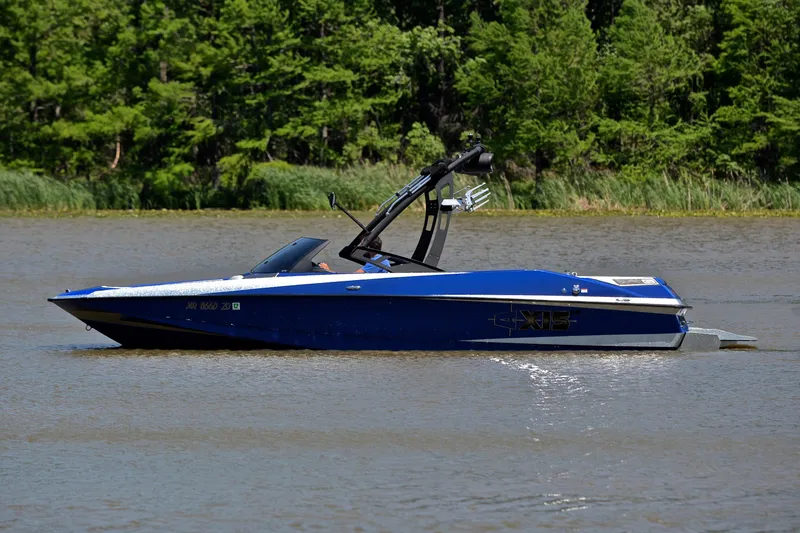 Slide: The Image of 2014 Axis A22 boat cruising on a river with lush green trees in the background. - 9