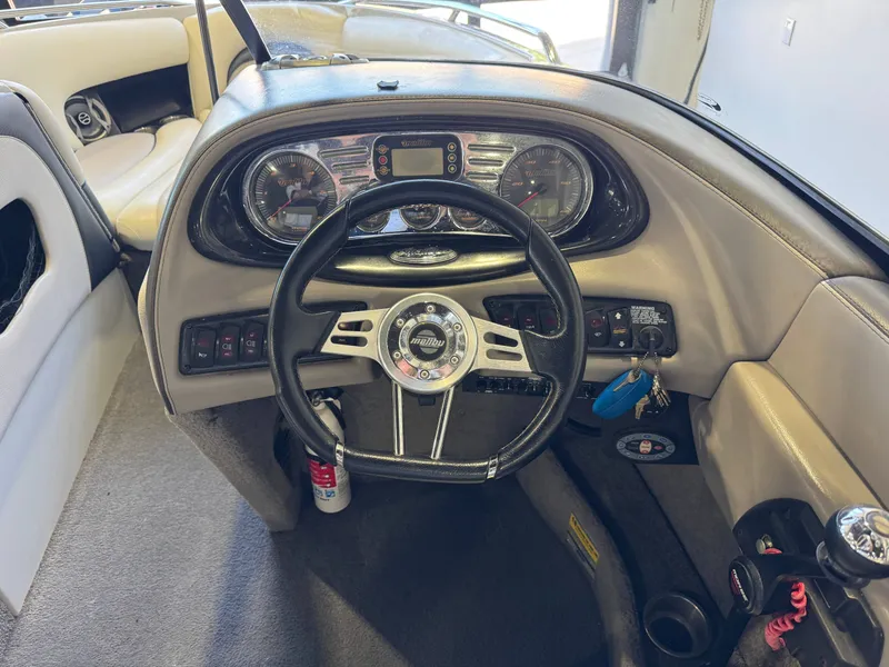 Slide: The Image of Interior of a 2006 Malibu 247 LSV boat with steering wheel and dashboard. - 25