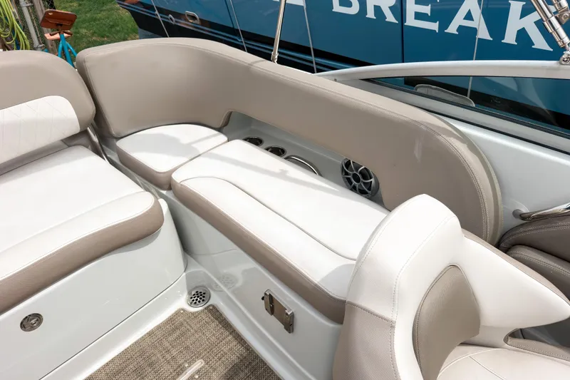 Slide: The Image of Interior seating of a 2018 Crownline Eclipse E215 XS boat, featuring beige and white upholstery. - 10