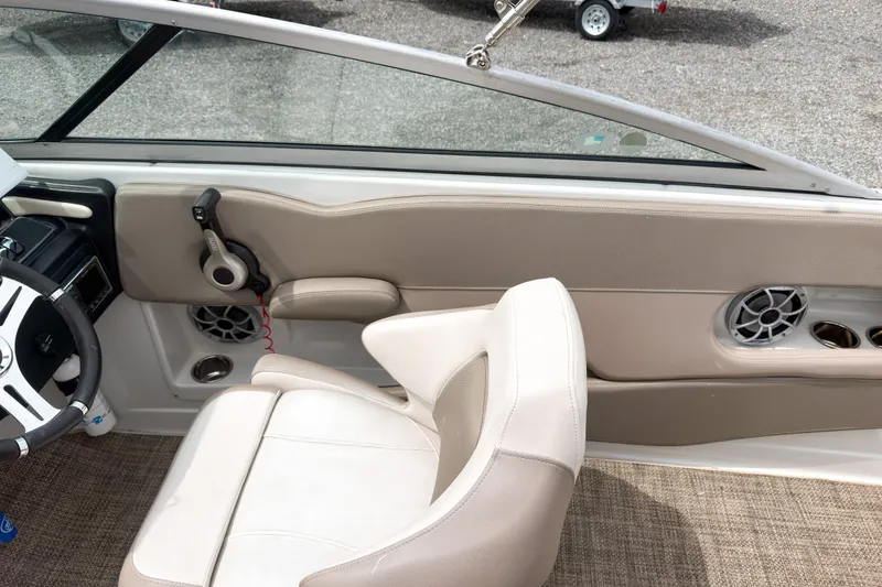 Slide: The Image of 2018 Crownline Eclipse E215 XS boat interior with beige seating and steering wheel. - 14