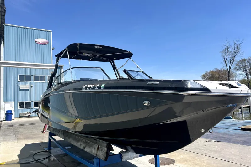 Slide: The Image of 2017 Scarab 255 H.O. Impulse boat on lift, blue sky background. - 2