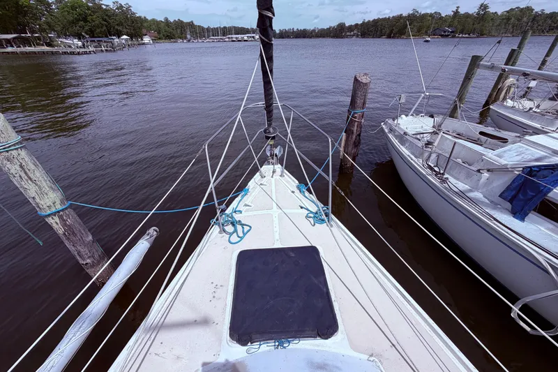 Slide: The Image of Bow view of a 1981 CAL 31 sailboat docked at a marina. - 10