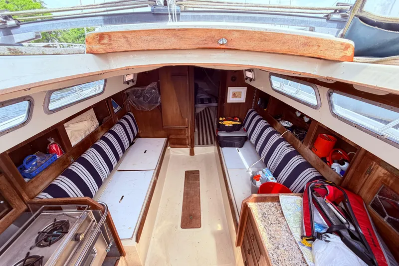 Slide: The Image of Interior of a 1981 CAL 31 sailboat with striped seating and wooden cabinetry. - 17