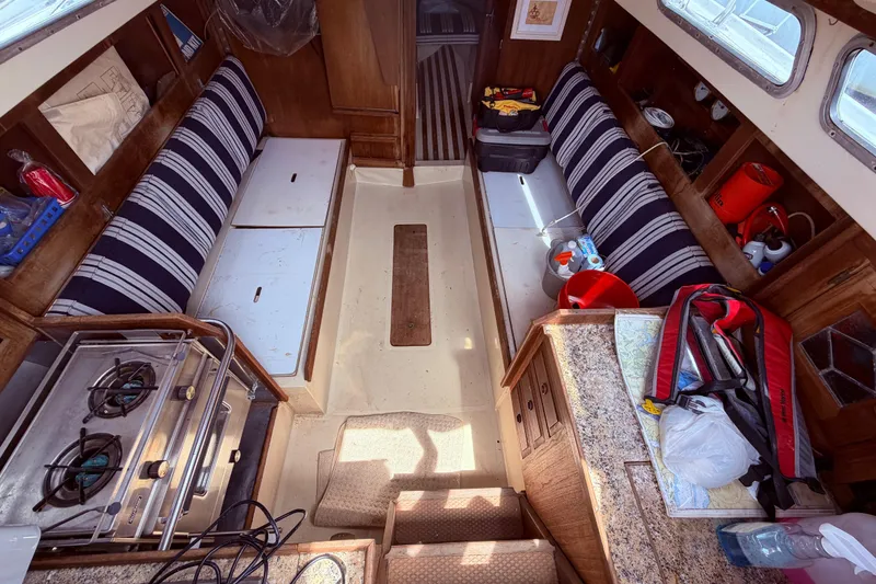 Slide: The Image of Interior of a 1981 CAL 31 sailboat with striped seating and compact kitchen area. - 18