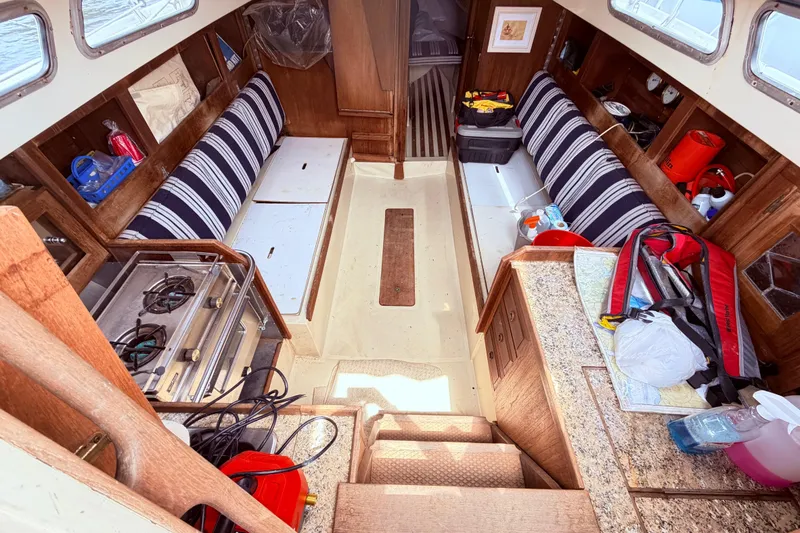 Slide: The Image of Interior of a 1981 CAL 31 sailboat with striped seating and compact kitchen area. - 21
