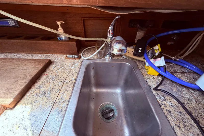 Slide: The Image of Small kitchen sink with faucet in a 1981 CAL 31 boat interior. - 23