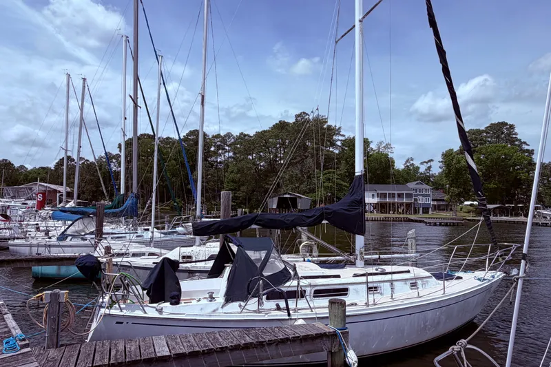 Slide: The Image of Sailboats docked at a marina, featuring a 1981 CAL 31 model. - 3