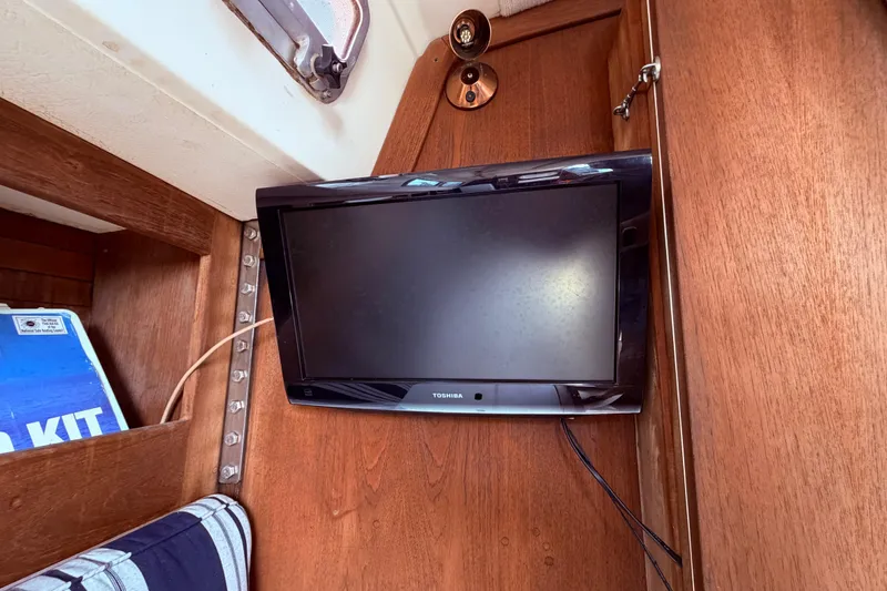 Slide: The Image of Toshiba TV mounted on wooden wall inside 1981 CAL 31 sailboat cabin. - 30
