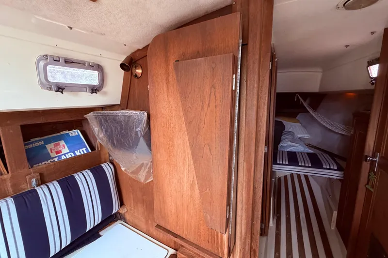 Slide: The Image of Interior of a 1981 CAL 31 sailboat with wood paneling and striped cushions. - 31