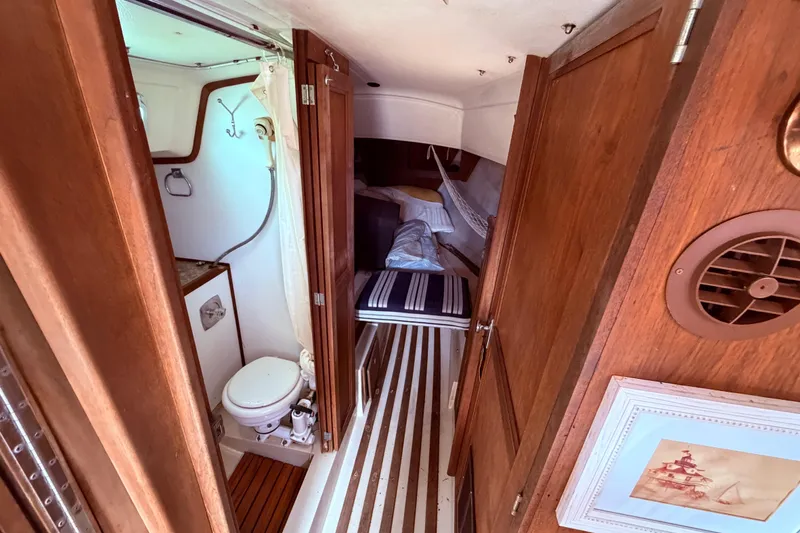 Slide: The Image of Interior of a 1981 CAL 31 sailboat featuring a compact bathroom and cozy sleeping area. - 32