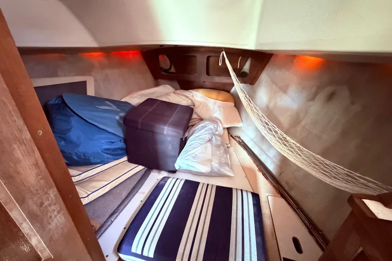 Slide: The Image of Cozy cabin interior of 1981 CAL 31 sailboat with striped cushions and storage. - 33