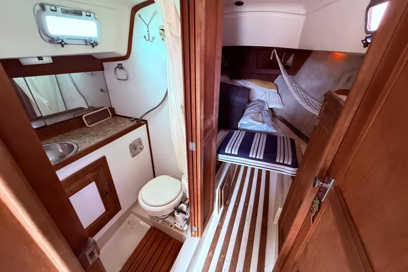 Slide: The Image of Interior of a 1981 CAL 31 sailboat featuring a compact bathroom and cozy sleeping area. - 38