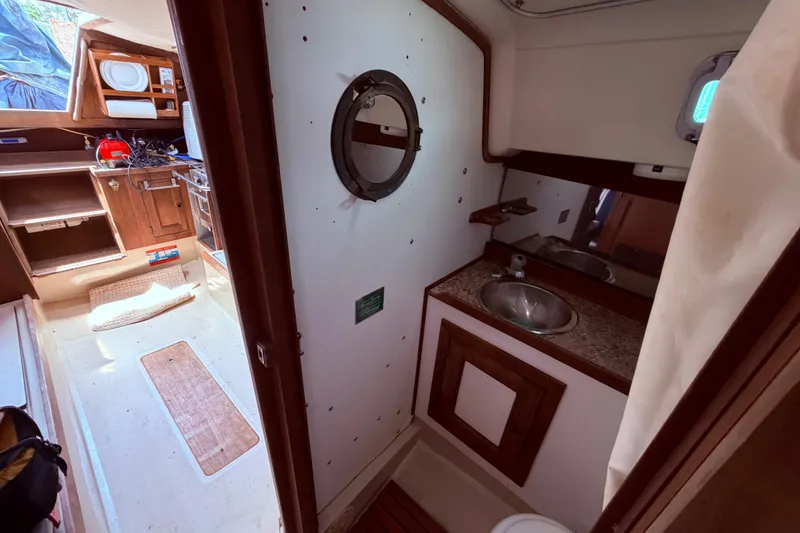 Slide: The Image of Interior of a 1981 CAL 31 sailboat featuring a compact bathroom and kitchenette. - 39