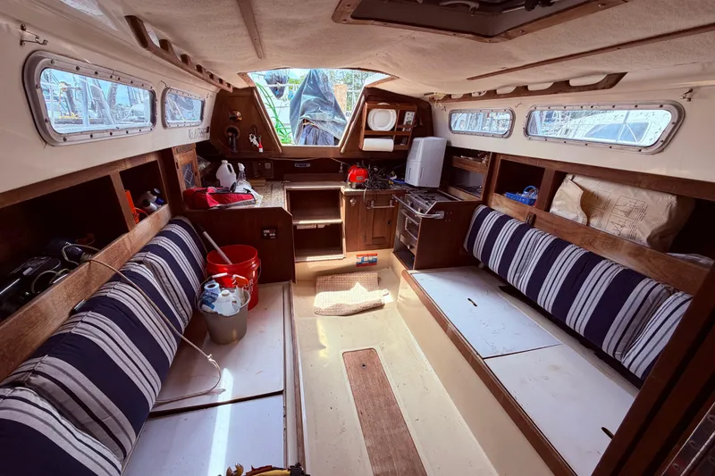 Slide: The Image of Interior of a 1981 CAL 31 sailboat with striped seating and wooden cabinetry. - 43