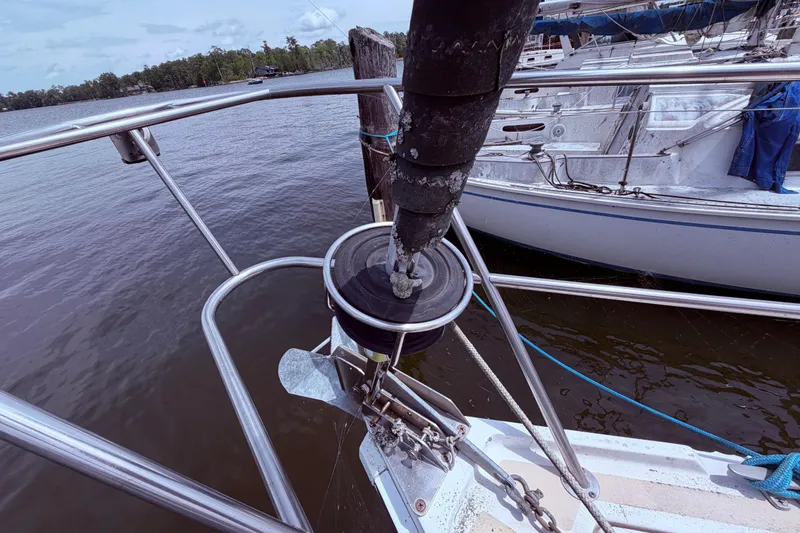 Slide: The Image of Bow of a 1981 CAL 31 sailboat with anchor and railing, docked by the water. - 6