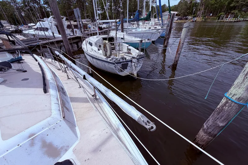 Slide: The Image of Docked sailboats, including a weathered 1981 CAL 31, at a marina. - 8