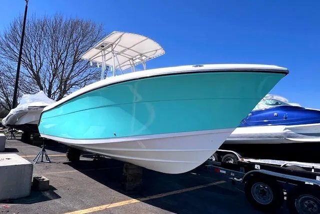 Slide: The Image of 2021 Cobia 237 Center Console boat on a trailer, turquoise color. - 3