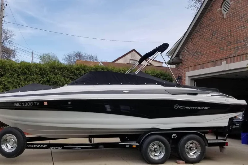 Slide: The Image of 2016 Crownline 225 SS boat on trailer, parked in driveway beside brick house. - 3