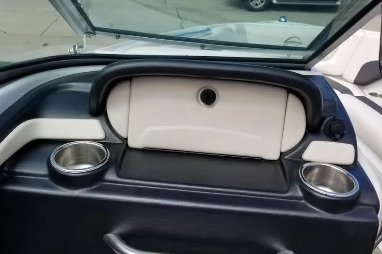 Slide: The Image of 2016 Crownline 225 SS boat dashboard with cup holders and storage compartment. - 5
