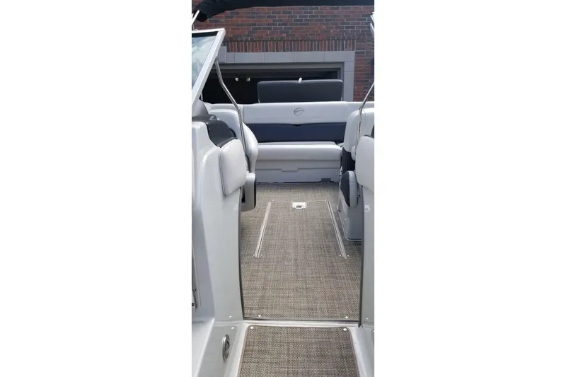 Slide: The Image of Interior view of a 2016 Crownline 225 SS boat, featuring sleek seating and carpeted flooring. - 7