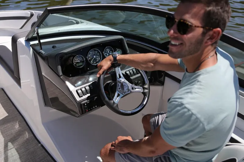 Slide: The Image of Manufacturer Provided Image: Man steering 2026 Monterey M-205 boat, smiling, wearing sunglasses, on a sunny day. - 5