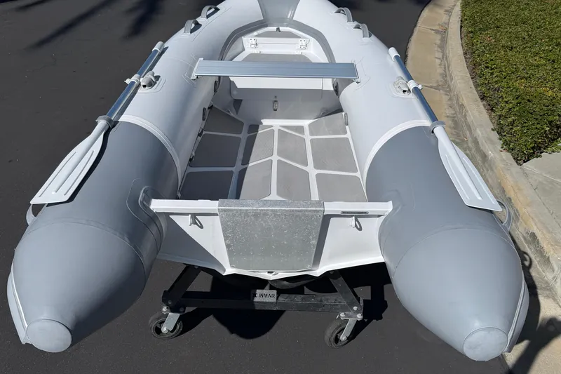 Slide: The Image of 2021 Inmar Aluma Lite 325R inflatable boat on a wheeled stand, gray and white design. - 3