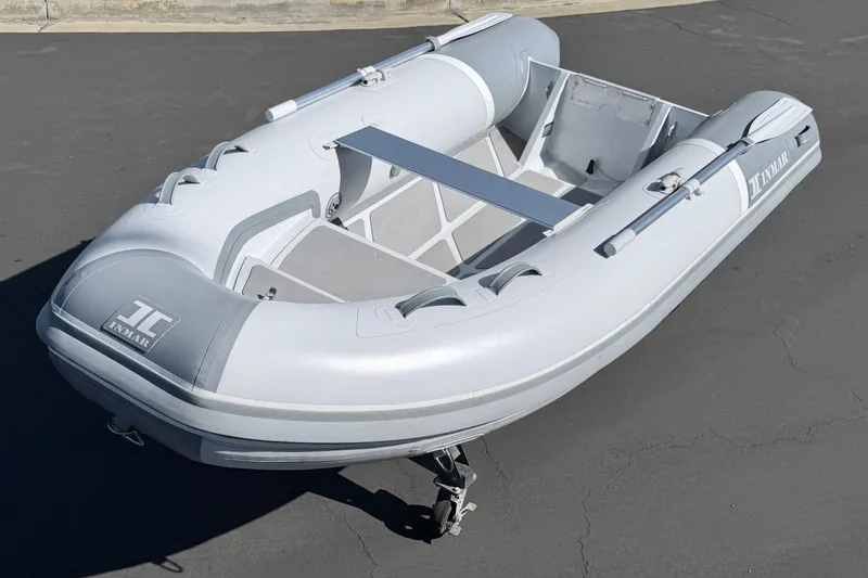 Slide: The Image of 2021 Inmar Aluma Lite 325R inflatable boat on pavement, showcasing sleek design and durable construction. - 7