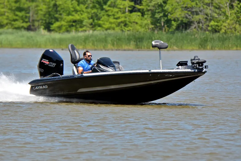 The Image of 2022 Caymas CX 20 boat speeding on a lake with a driver, surrounded by greenery. - 1