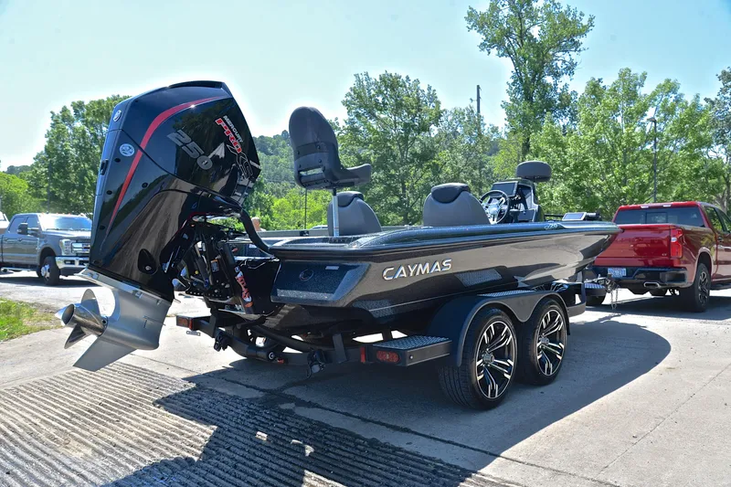 Slide: The Image of 2022 Caymas CX 20 boat on trailer with powerful outboard motor, parked outdoors. - 13