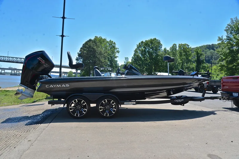 Slide: The Image of 2022 Caymas CX 20 boat on trailer by riverside, under clear blue sky. - 14