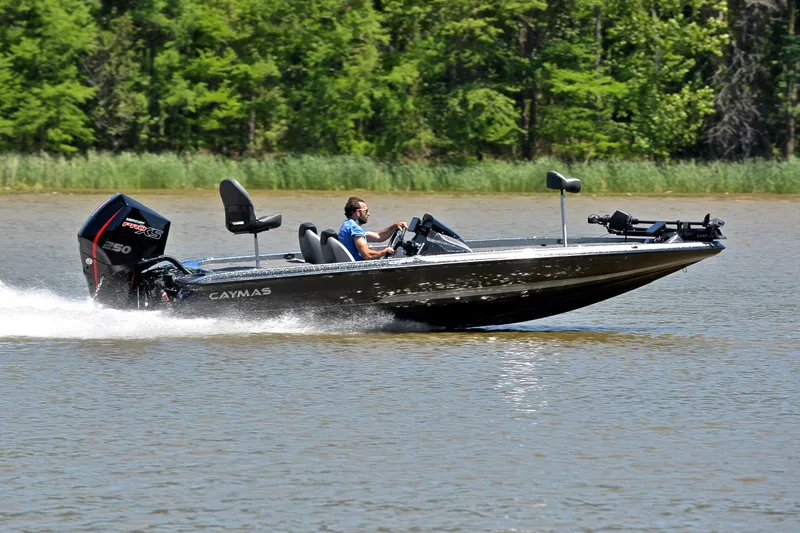 Slide: The Image of 2022 Caymas CX 20 boat speeding on a lake with lush green trees in the background. - 3