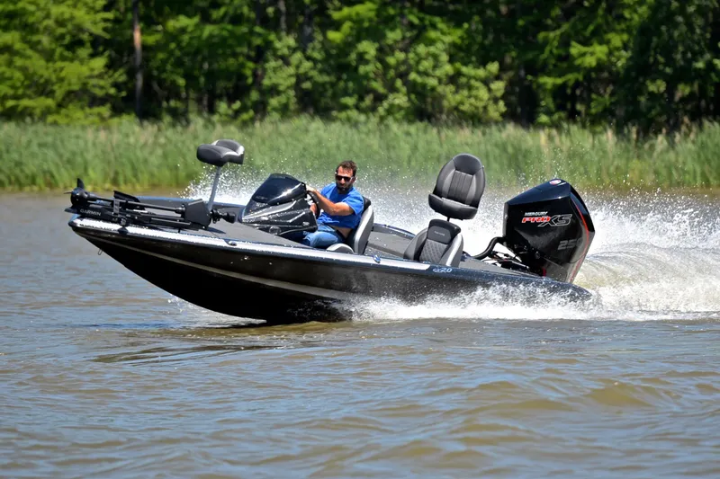 Slide: The Image of 2022 Caymas CX 20 boat speeding on a lake with lush green background. - 4