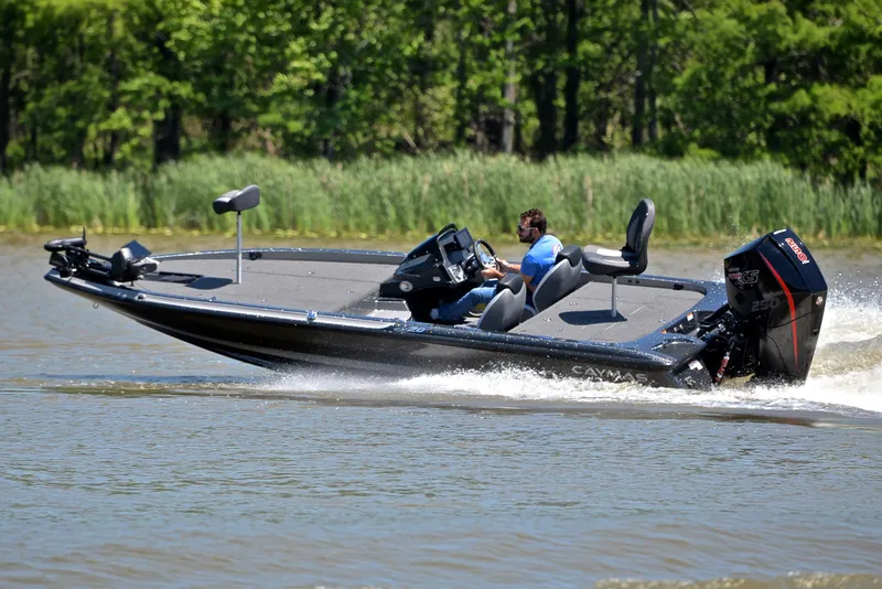 Slide: The Image of 2022 Caymas CX 20 boat speeding on a lake with lush green background. - 5