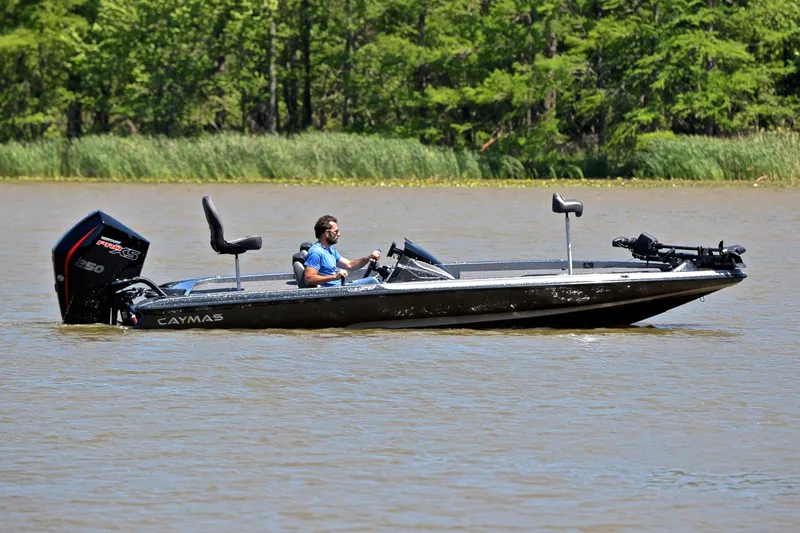 Slide: The Image of 2022 Caymas CX 20 boat cruising on a lake with lush green trees in the background. - 6